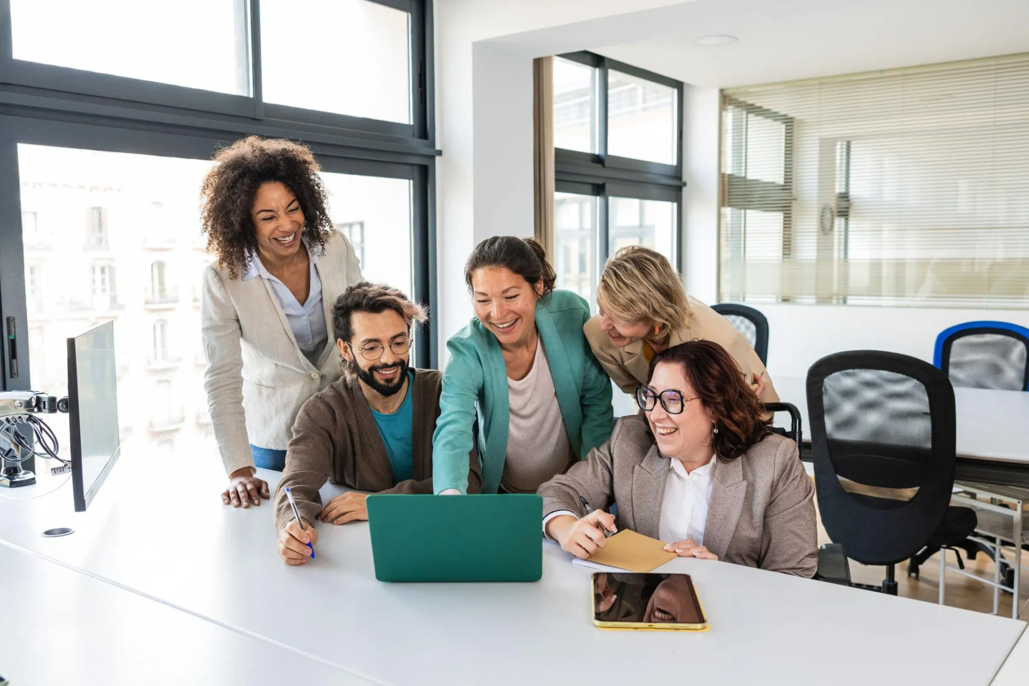 A small business team using a connected B2B software stack on laptops and a wall display, top of post hero image