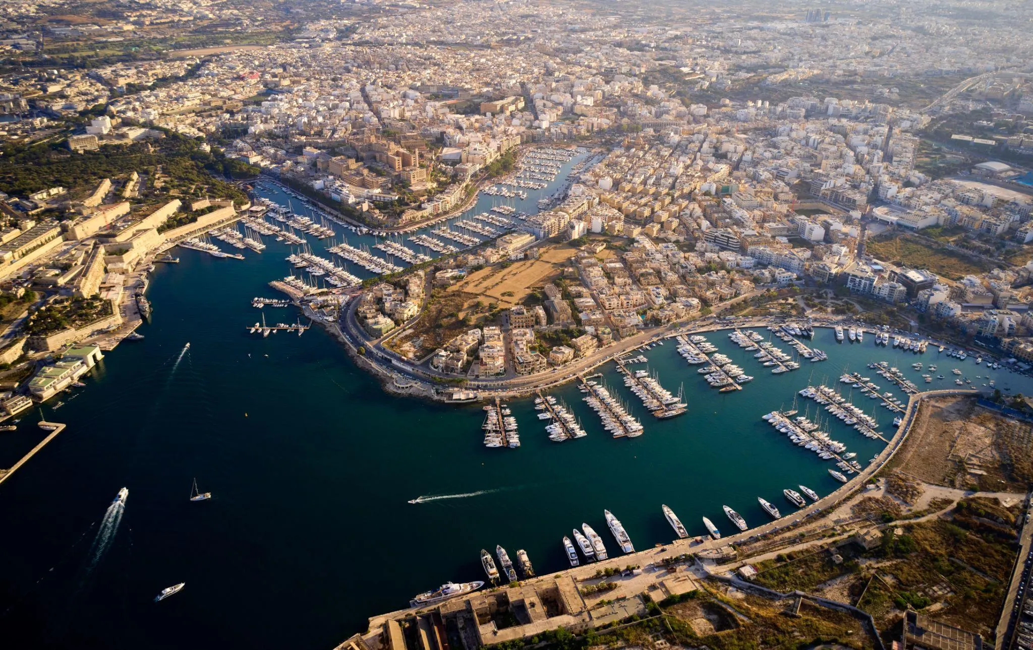 Aerial view of Valletta harbour with overlay of code editor and developer hiring funnel, hero image above the fold